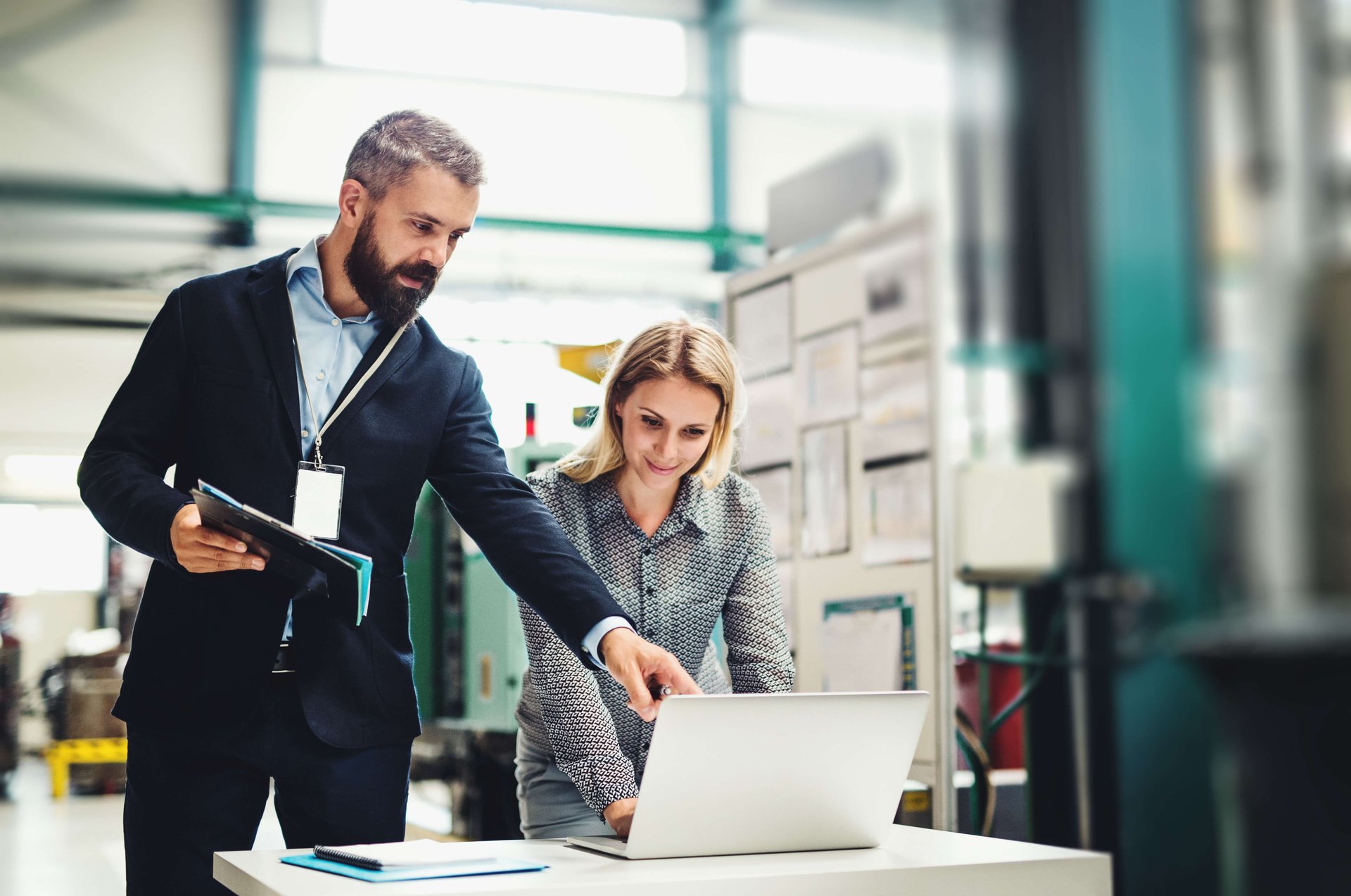 Man and woman in front of screen in industrial environment